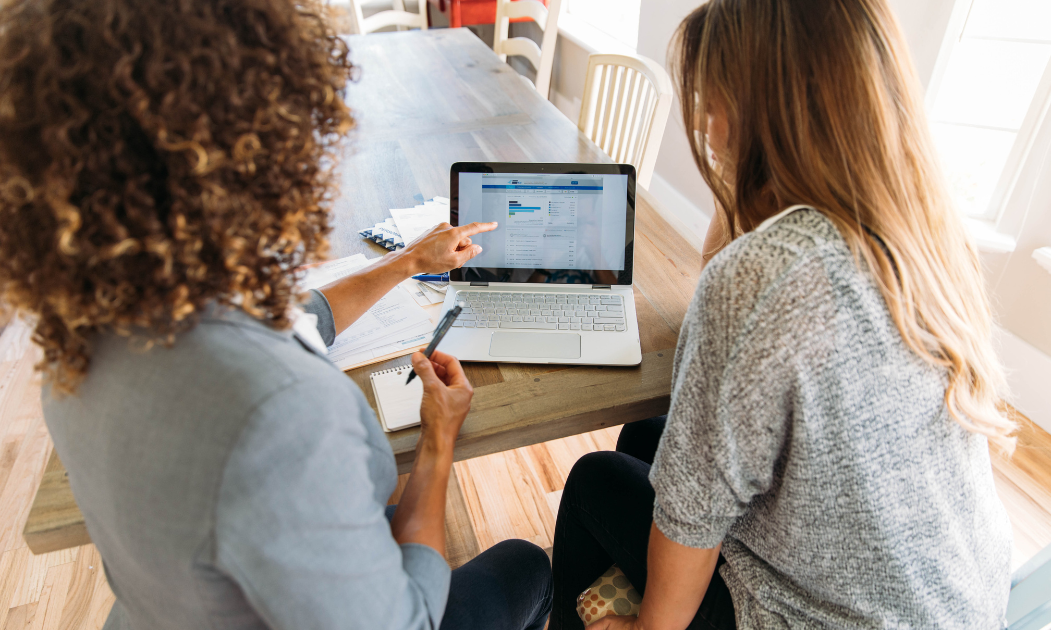 Two women both looking at a laptop